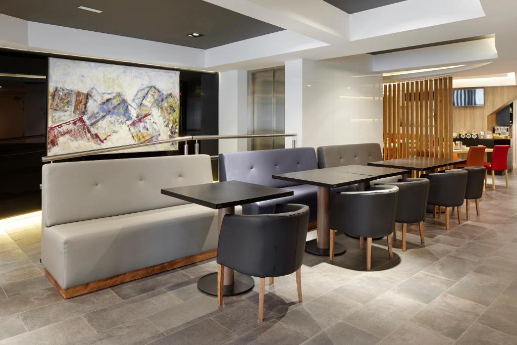 a restaurant with tables and chairs and a couch at Hotel Parma in San Sebastián
