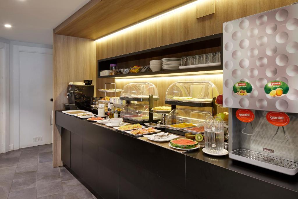 a buffet line in a restaurant with food at Hotel Parma in San Sebastián