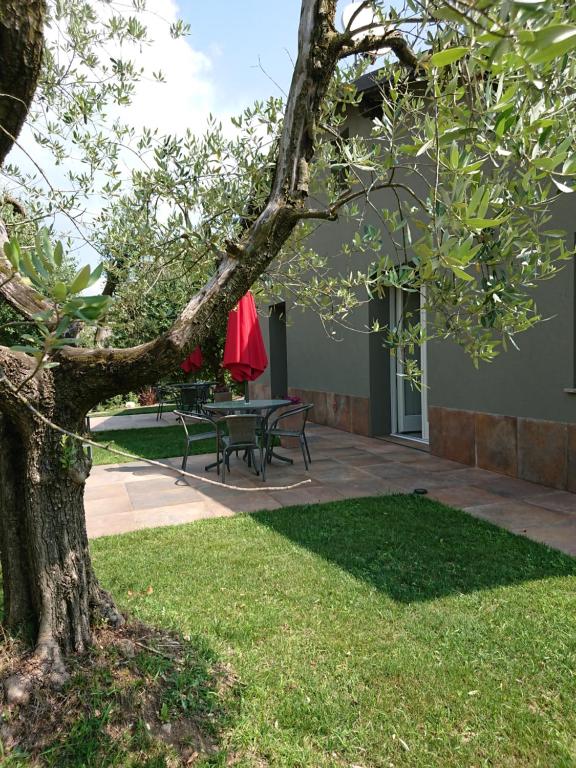 d'une terrasse avec une table et un parasol rouge. dans l'établissement Il carpino bianco, à Puegnago