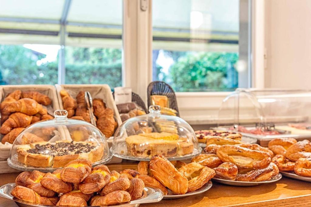 a table filled with different types of pastries and pies at Guerrini Hotel in Castiglioncello