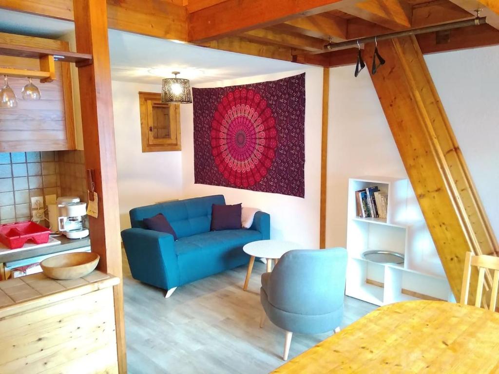 un soggiorno con divano blu e tavolo di Appartement lumineux avec balcon à Arêches Beaufort a Beaufort