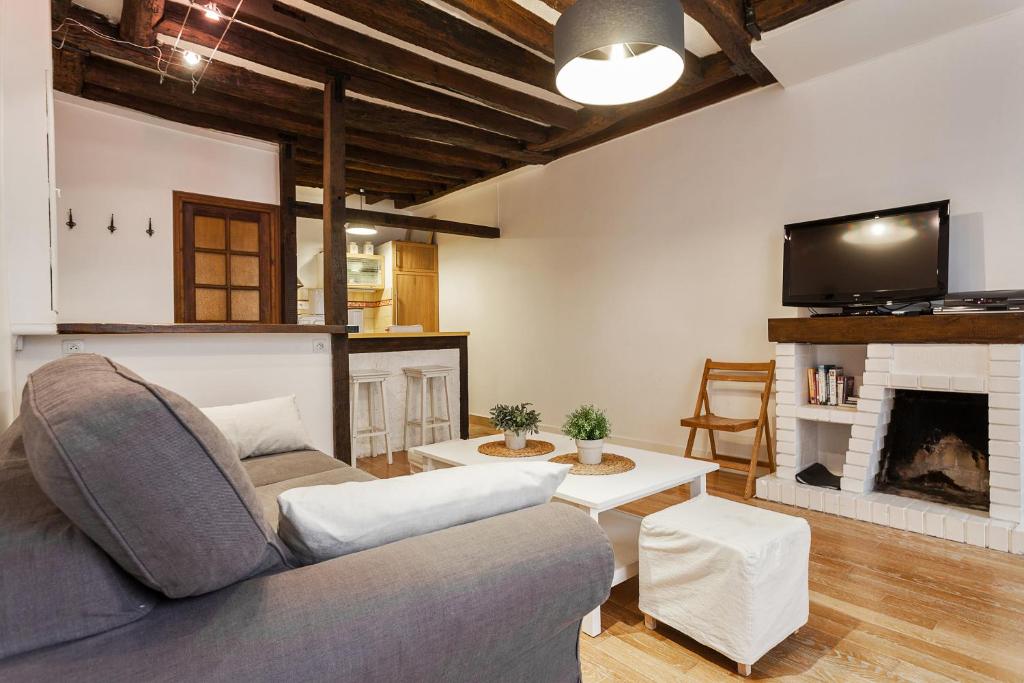 uma sala de estar com um sofá e uma lareira em Apartment Saint Jacques Notre Dame de Paris em Paris