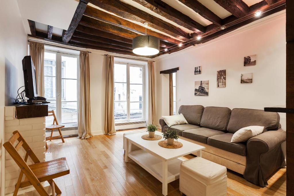 uma sala de estar com um sofá e uma mesa em Apartment Saint Jacques Notre Dame de Paris em Paris