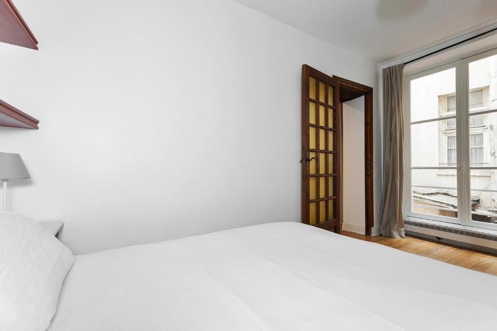 Uma cama ou camas num quarto em Apartment Saint Jacques Notre Dame de Paris
