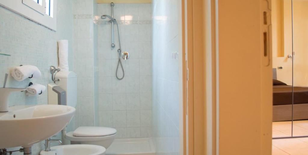 a bathroom with a shower and a toilet and a sink at Guerrini Hotel in Castiglioncello