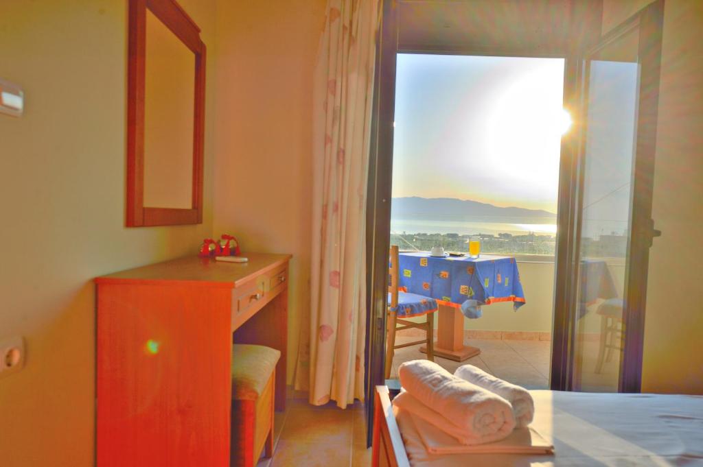 a bedroom with a bed and a mirror and a room with a window at Xenios Zeus Apartments in Kissamos