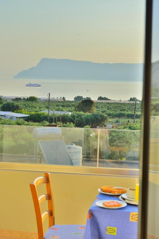 a table with a view of the ocean from a window at Xenios Zeus Apartments in Kissamos