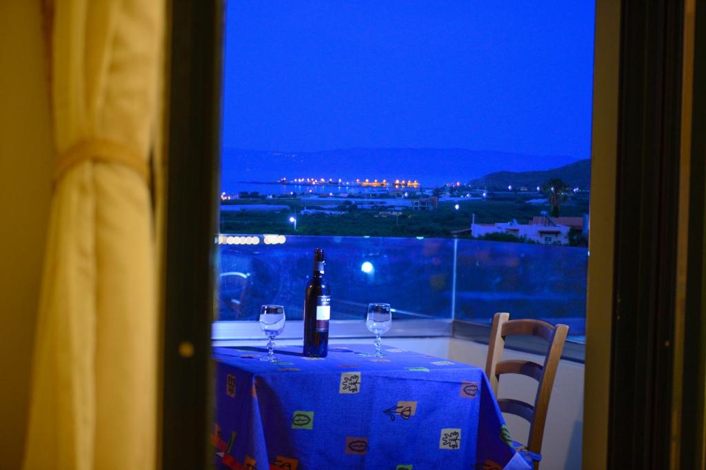a table with two glasses and a bottle of wine at Xenios Zeus Apartments in Kissamos