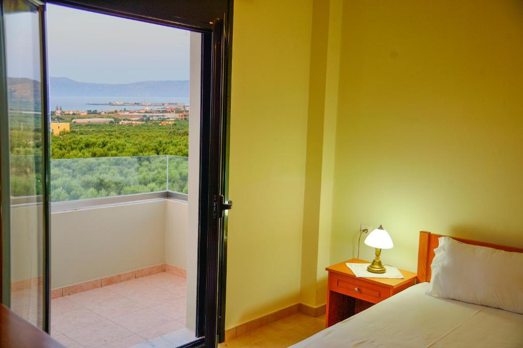 a bedroom with a bed and a window with a view at Xenios Zeus Apartments in Kissamos