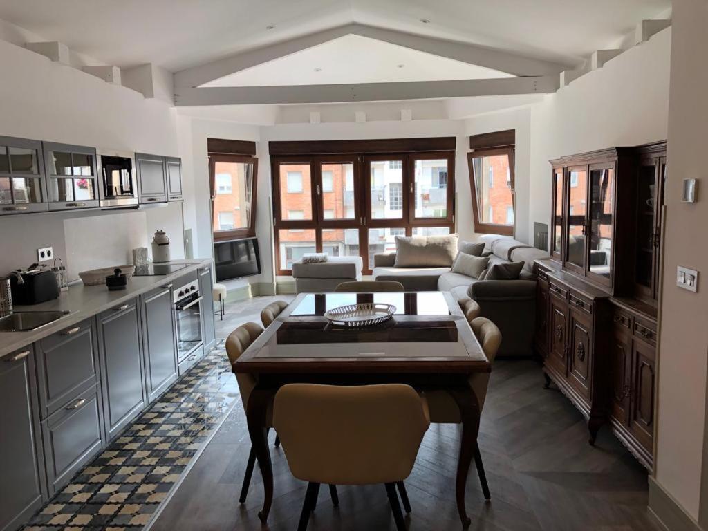 a kitchen with a table and a living room at Casa Abego in Cangas de Onís