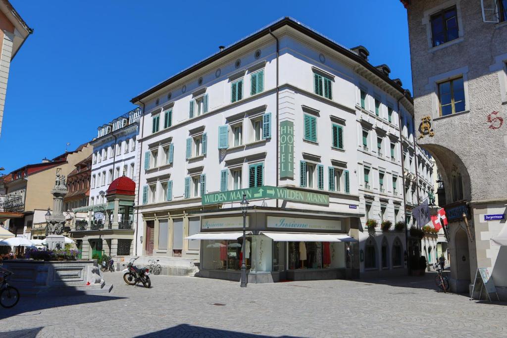 ein großes weißes Gebäude in einer Stadtstraße in der Unterkunft Romantik Hotel Wilden Mann Luzern in Luzern