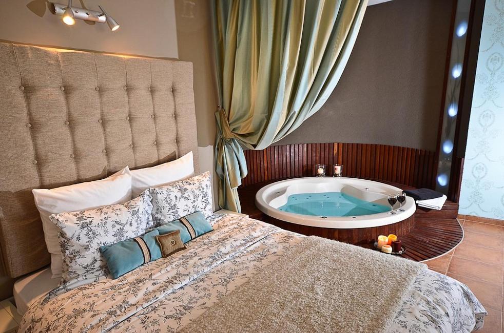 1 dormitorio con 1 cama grande y bañera en Hufsha Berama, en Had Nes