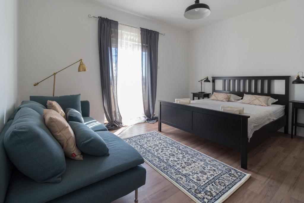 1 dormitorio con sofá azul y cama en Apartments Duka, en Zadar