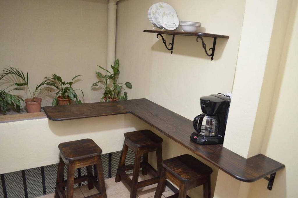 a counter with two stools and a coffee maker at #4 Private room close to Airport in Alajuela