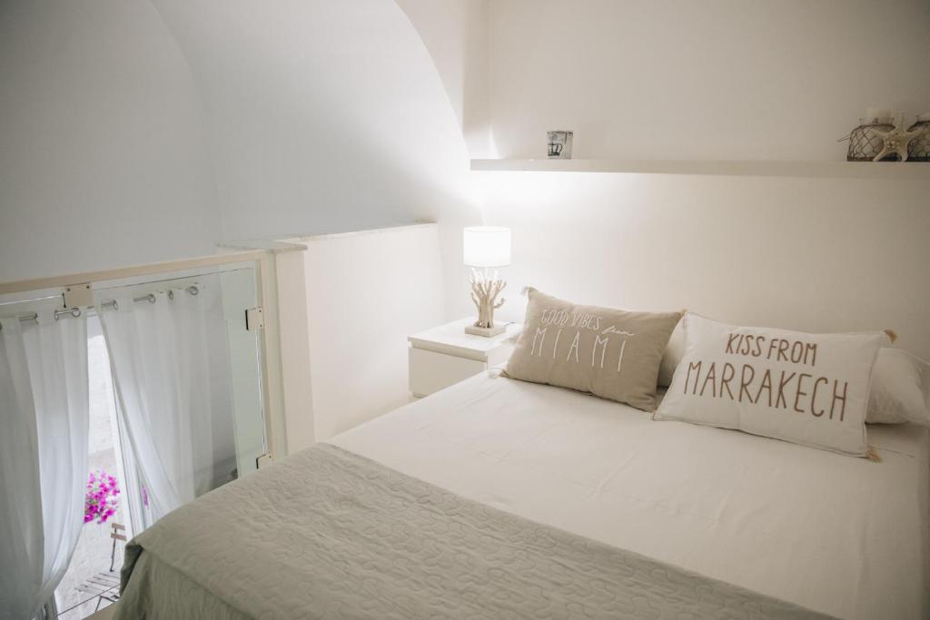 - une chambre blanche avec un lit et une fenêtre dans l'établissement Palazzo Massari Bari, à Bari