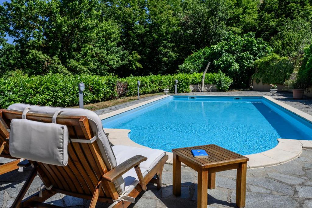krzesło i stół obok basenu w obiekcie Tenuta Pian D'Attesio - Agriturismo w mieście Castelletto Soprano