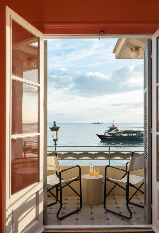 a balcony with a view of the ocean and a boat at AiR Waterfront Nikis Apartment in Thessaloniki