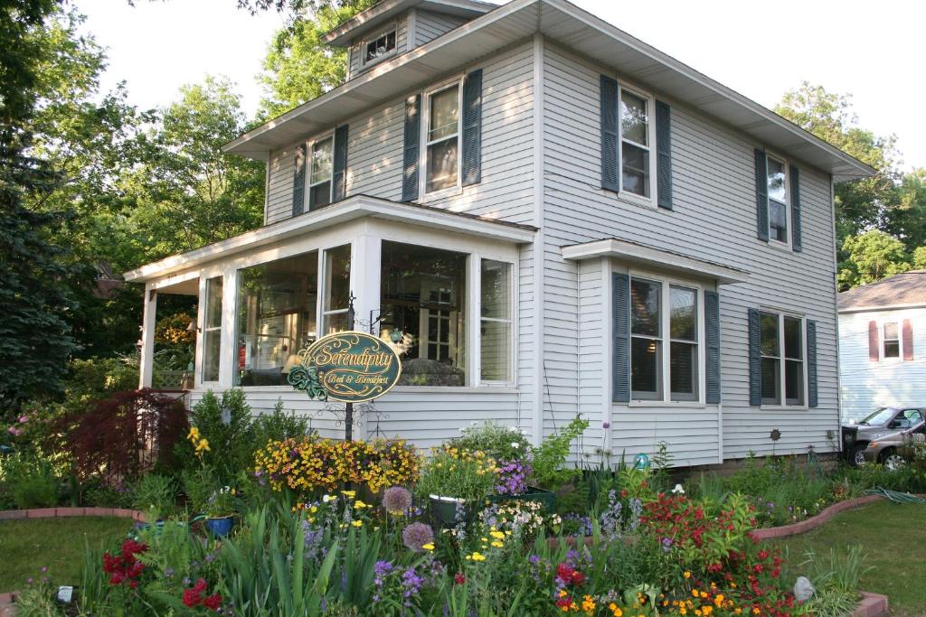 a house with a flower garden in front of it at Serendipity Bed and Breakfast in Saugatuck