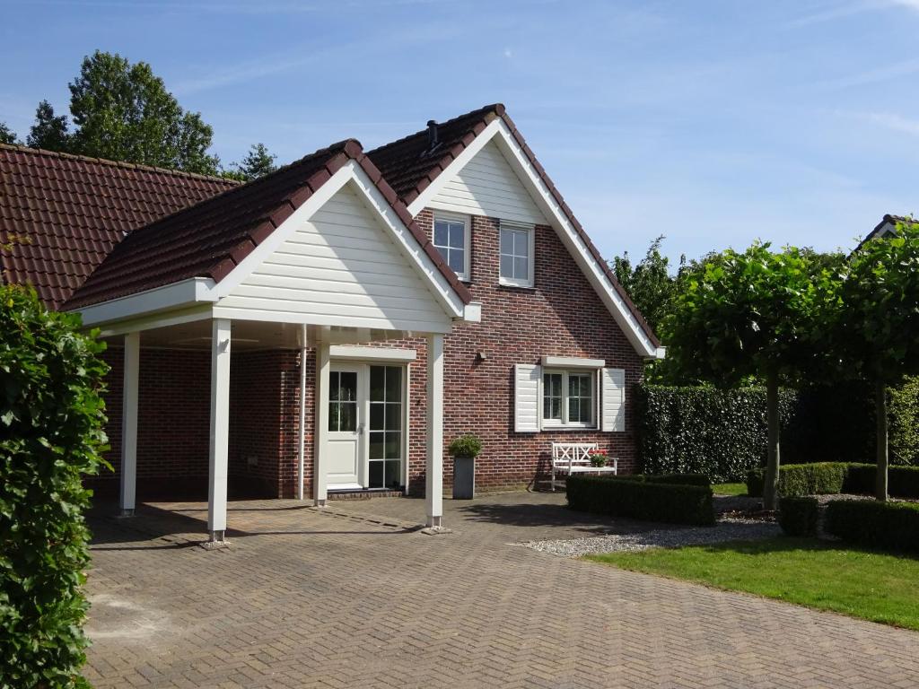 une maison en briques avec une porte blanche dans une allée en briques dans l'établissement Holiday Home Zeewolde, à Zeewolde