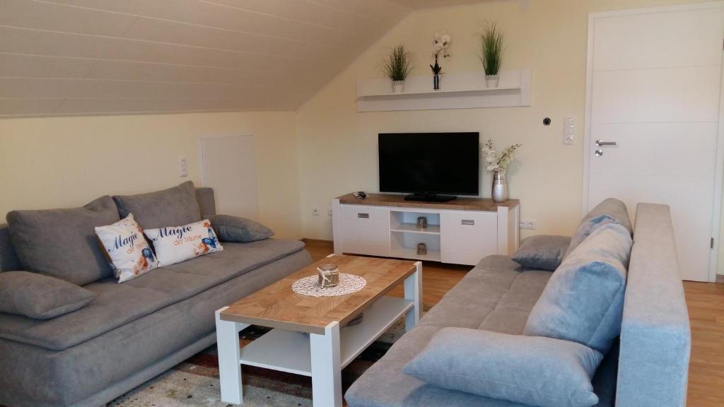 uma sala de estar com dois sofás e uma televisão em Ferienwohnung Giovanni em Schwandorf