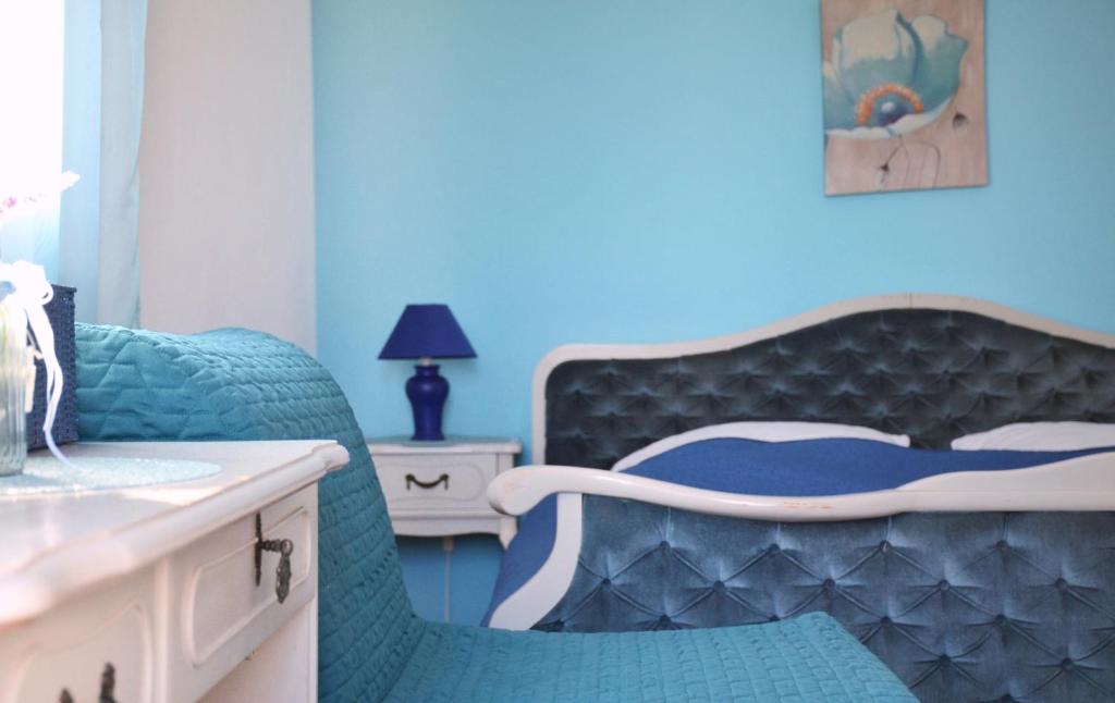 Dormitorio azul con cama y lavamanos en Apartman I&A, en Porat