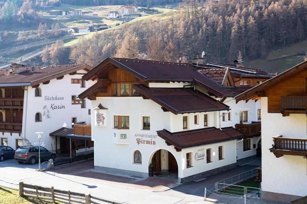 un grupo de edificios con montañas en el fondo en Appartement Pirmin, en Sölden