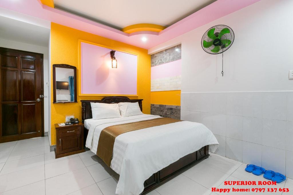 a bedroom with a bed and yellow walls at Happy Home in Ho Chi Minh City