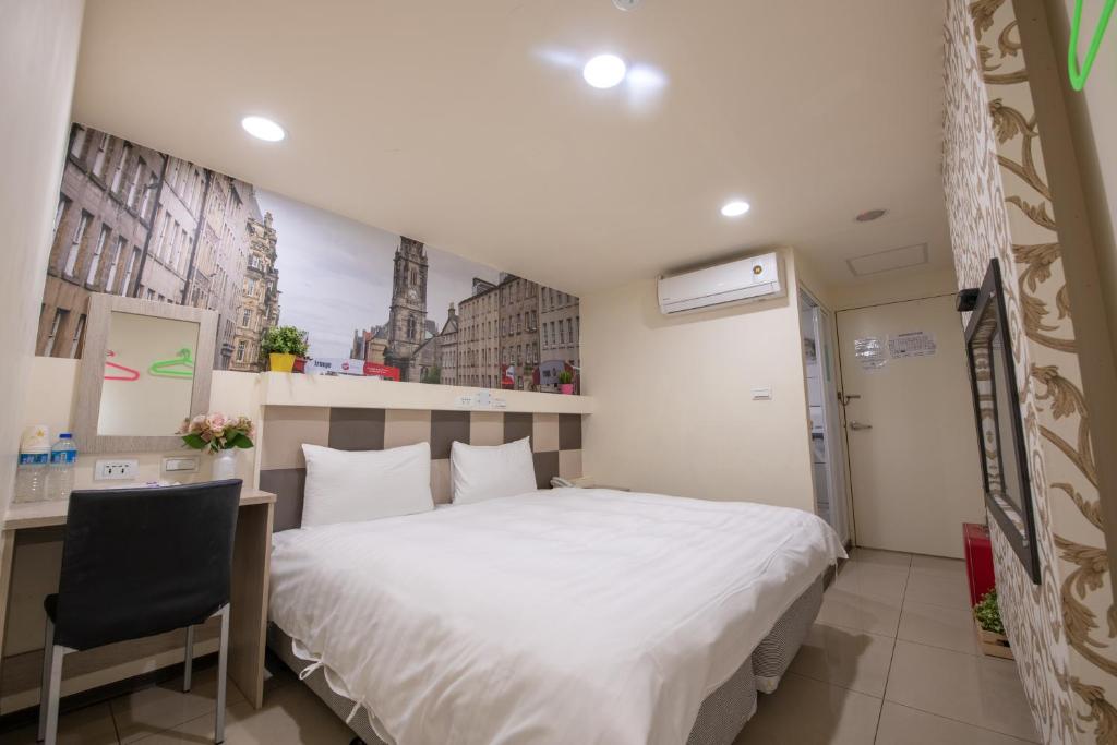 um quarto com uma grande cama branca e uma secretária em England Vacation Hotel em Zhongli