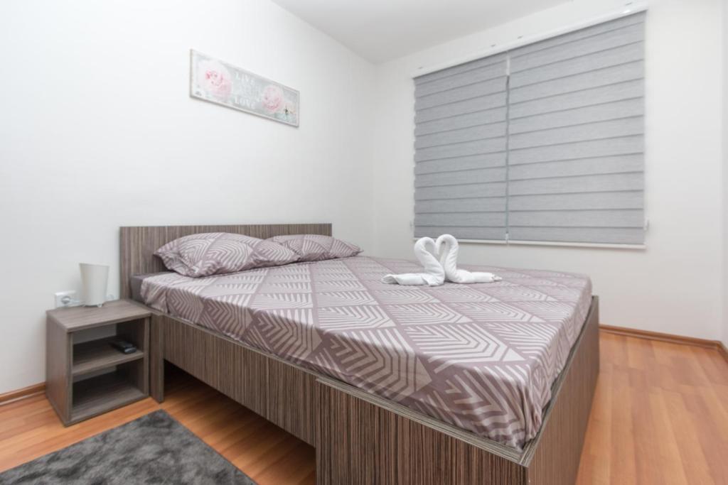 ein Schlafzimmer mit einem Bett mit einem weißen Stofftier drauf in der Unterkunft Apartman Emir 1 in Sarajevo