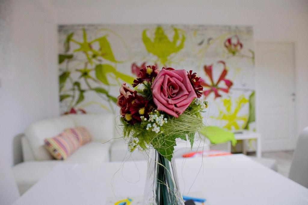 a vase with a pink rose sitting on a table at Ioan Budai-Deleanu Apartment in Cluj-Napoca