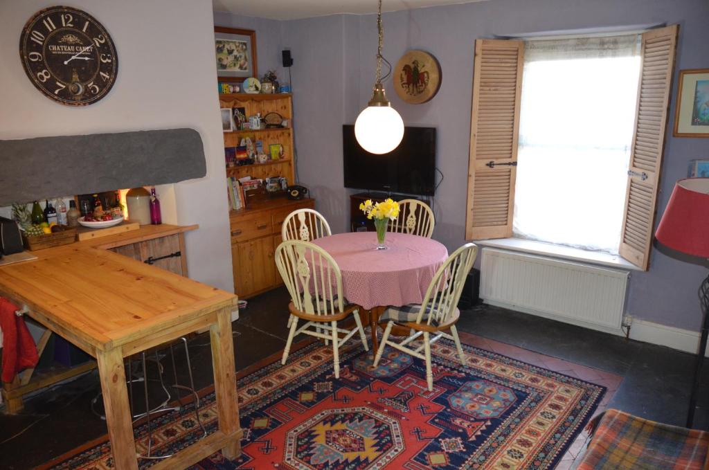 a dining room with a table and chairs and a window at Cynfaen house in Corwen