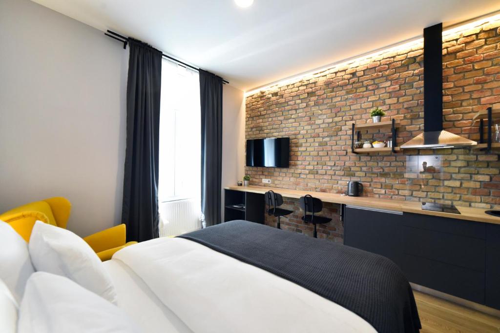 une chambre d'hôtel avec un lit et un mur en briques dans l'établissement Imperial Apartment Z, à Zagreb