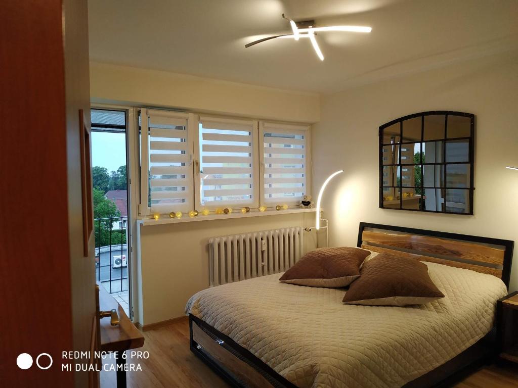 sypialnia z łóżkiem i oknem z białymi okiennicami w obiekcie Apartament Briesen w mieście Wąbrzeźno