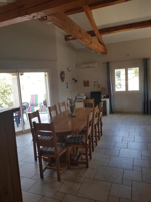 una sala da pranzo con tavolo e sedie in legno di Villa au calme dans un pittoresque petit village a Montpezat