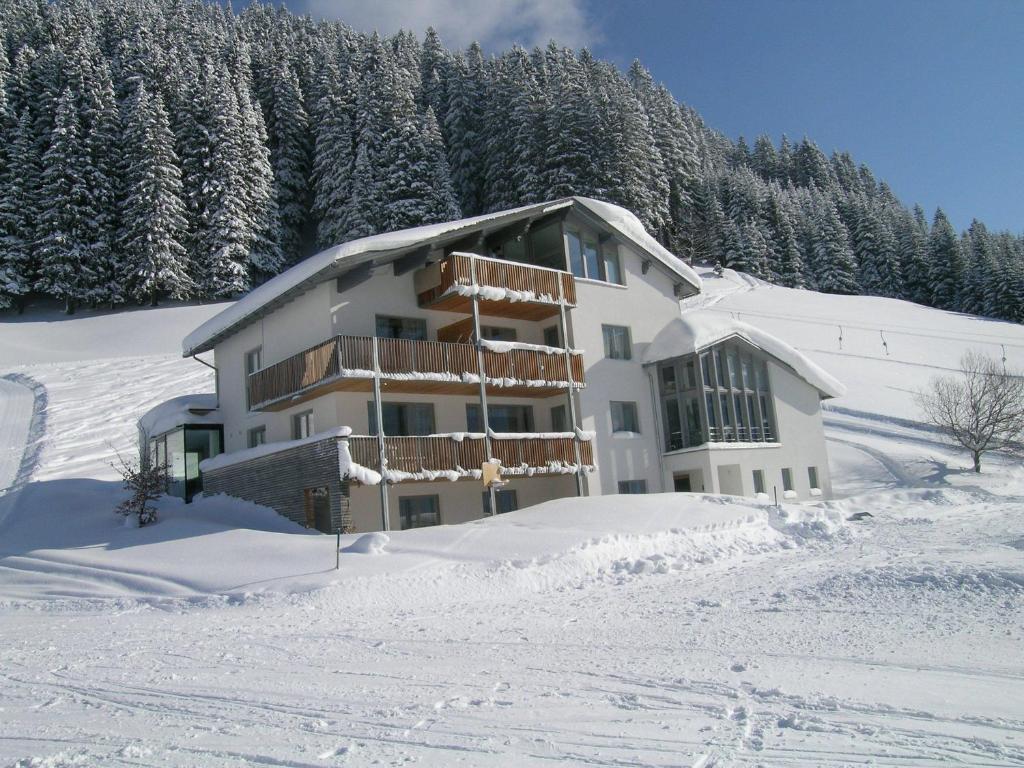 a large building in the snow with trees at Ferienwohnungen Abel in Damuls