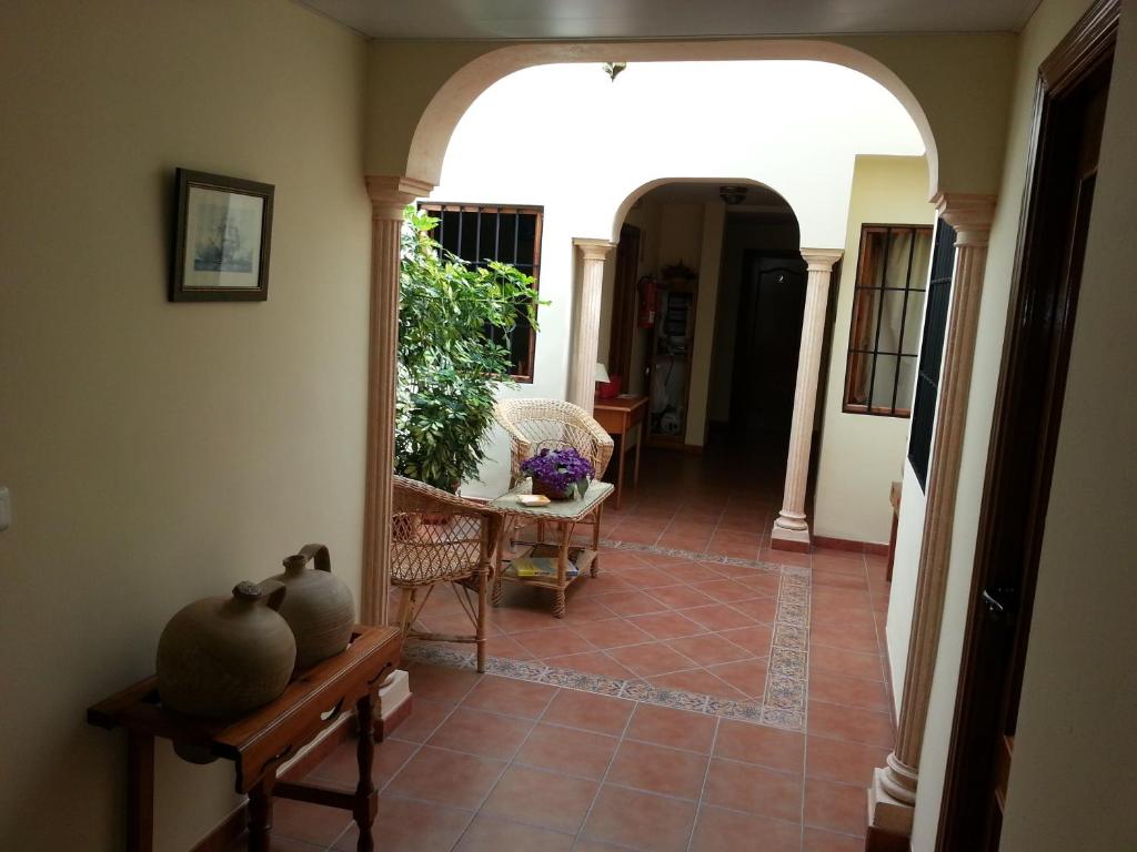 a hallway of a house with a table and chairs at Pensión y apartamentos El Taxi in Casabermeja