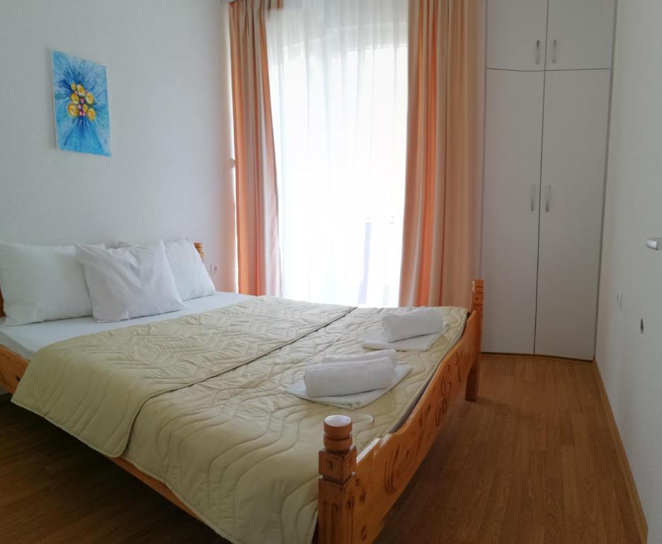 uma cama num quarto com uma grande janela em Petroski Apartments em Ohrid