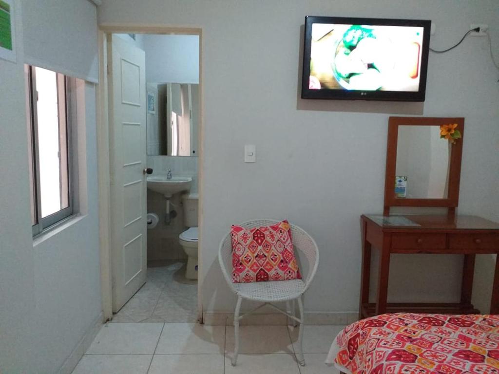a bedroom with a bed and a tv on the wall at Hotel Orquídea Neiva in Neiva