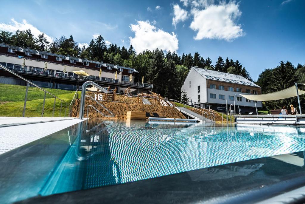 a swimming pool with a slide in front of a building at Hotel Monínec - Depandance Nová Javorka in Moninec