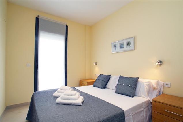 een slaapkamer met een bed met handdoeken erop bij Apartamentos Sitges in Sitges