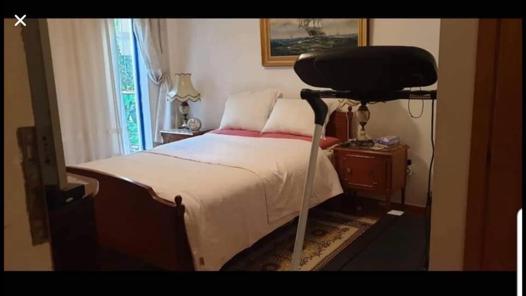 ein Schlafzimmer mit einem Bett und einem schwarzen Stuhl in der Unterkunft Sava’s apartment in Varkiza