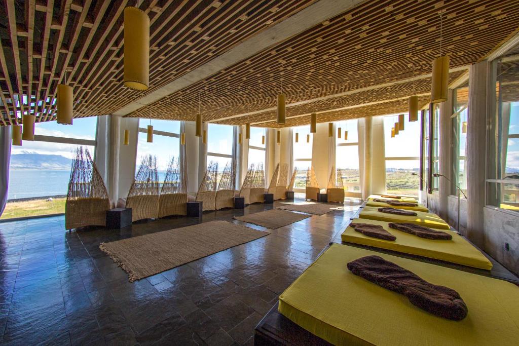 a row of tables in a room with windows at Remota Patagonia Lodge in Puerto Natales