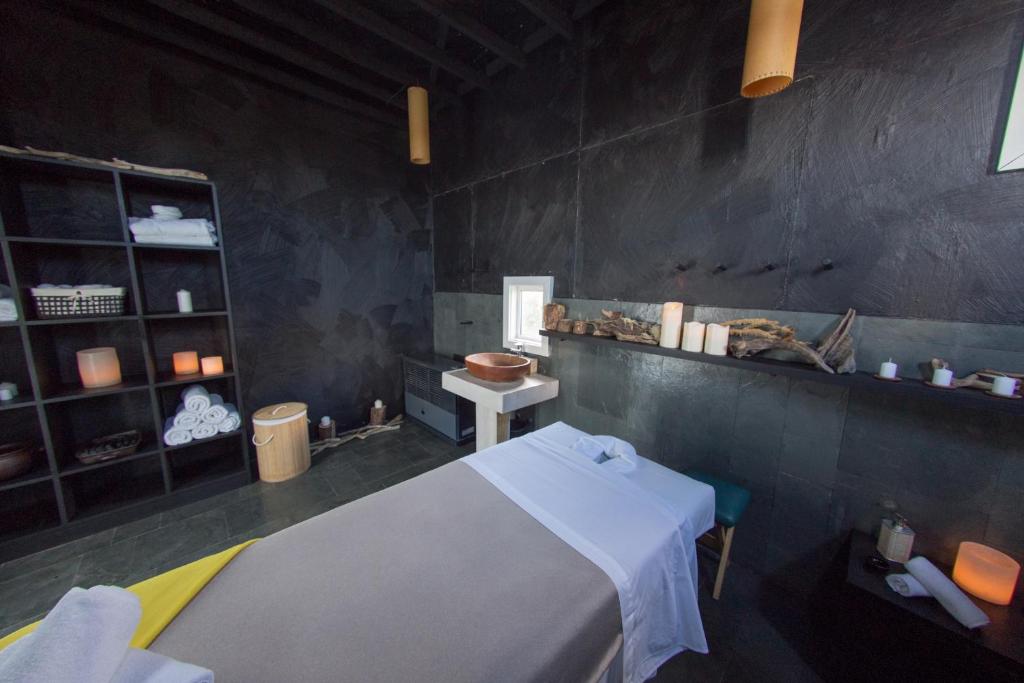 a room with a bed and a table and a shelf at Remota Patagonia Lodge in Puerto Natales