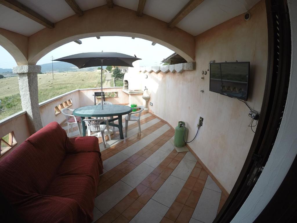 a living room with a couch and a table with an umbrella at Casa Vacanze residence Cavour Attico in Valledoria