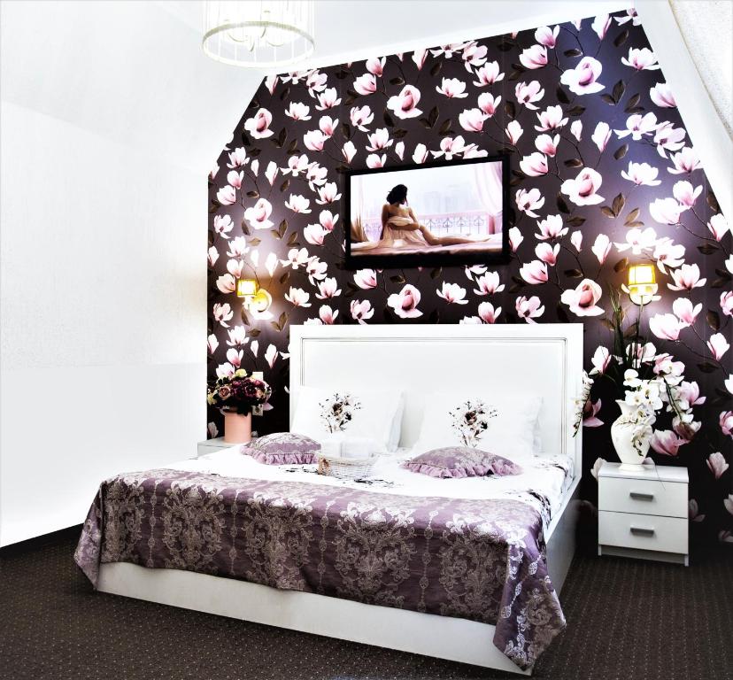 ロストフ・ナ・ドヌにあるBoutique-Hotel Provenceの花柄の壁のベッドルーム1室