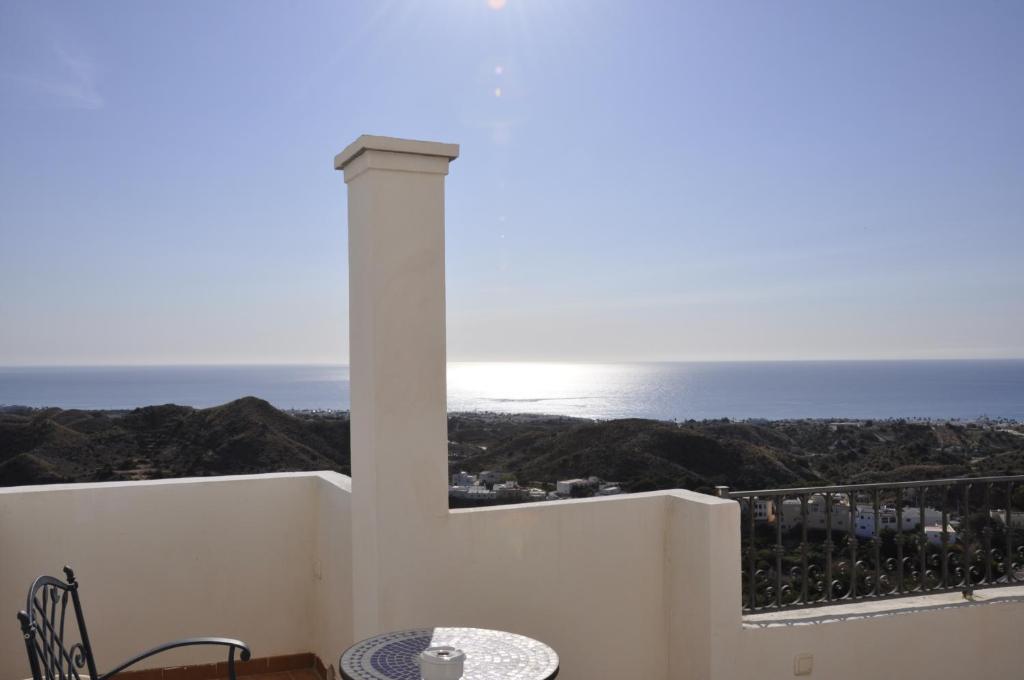 balcón con mesa y vistas al océano en Boutique Hotel Mamabels, en Mojácar