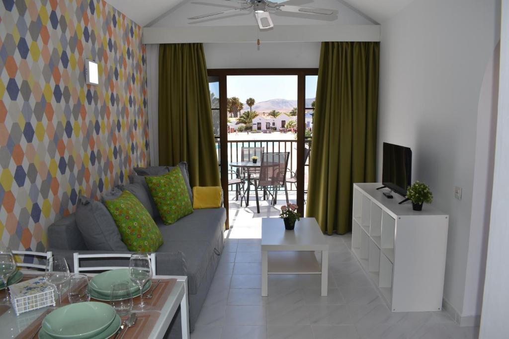 a living room with a couch and a television at Casa Verol, F2 in Caleta De Fuste