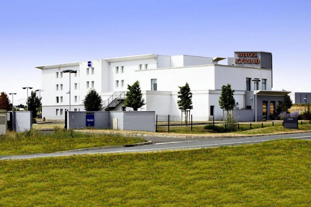 a white building with a sign on it at Kyriad Chartres in Chartres