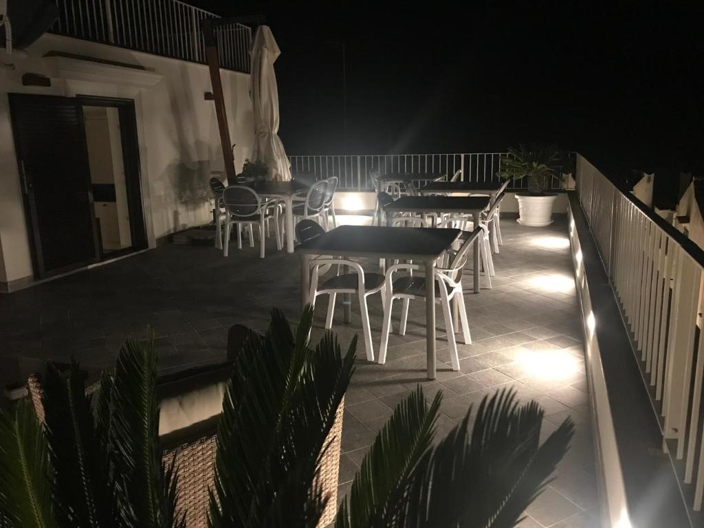 a patio with tables and chairs on a balcony at night at Estlevante B&B in Vieste