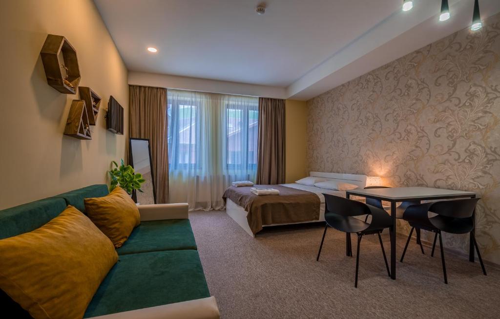 a hotel room with a bed and a couch and a table at New Gudauri Suites N317 in Gudauri